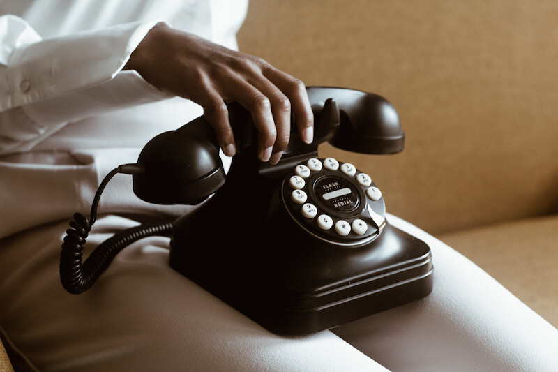 woman sitting with retro phone