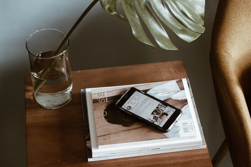 Inspiring magazines and iPhone on table with green plant